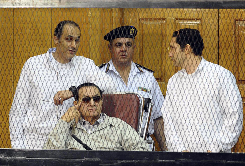 Former Egyptian President Hosni Mubarak, seated, and his sons Gamal Mubarak, left, and Alaa Mubarak, right, attend a hearing Saturday in Cairo, Egypt. The ousted autocrat was in court for the resumption of his retrial on charges related to the killings of 900 protesters in 2011.
