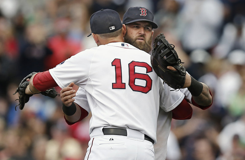 Will Middlebrooks, front, and Mike Napoli celebrate after Boston’s 5-1 win over the Yankees on Saturday at Fenway Park. The Red Sox will try for a series sweep Sunday night.