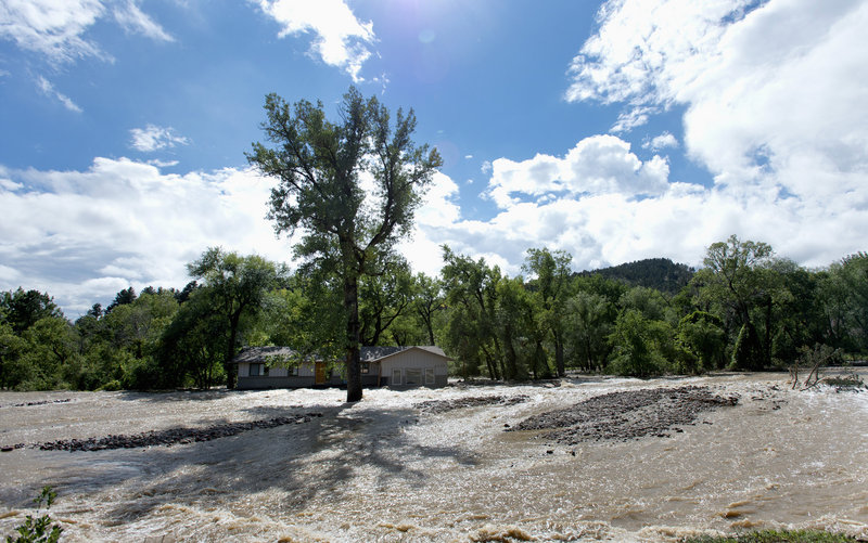 A home with floodwaters from Left Hand Creek running on both sides is seen in Boulder, Colo., on Monday. Colorado flooding was triggered by a week of torrential downpours.