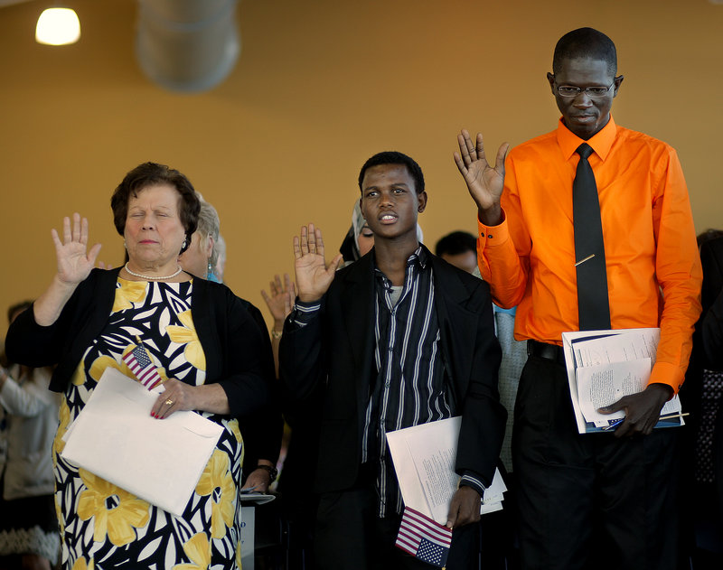 Left to right, Lorisse Matta, 58, of Buxton, originally from Lebanon, Mohamed Ali, 19, of Lewiston, originally from Kenya, and Mamadou Diallo, 32, of Bangor, originally from Mali, were three of 75 immigrants who took the Oath of Allegiance to become U.S. citizens at a Naturalization Ceremony held at Ocean Gateway on Tuesday, Sept. 17, 2013.