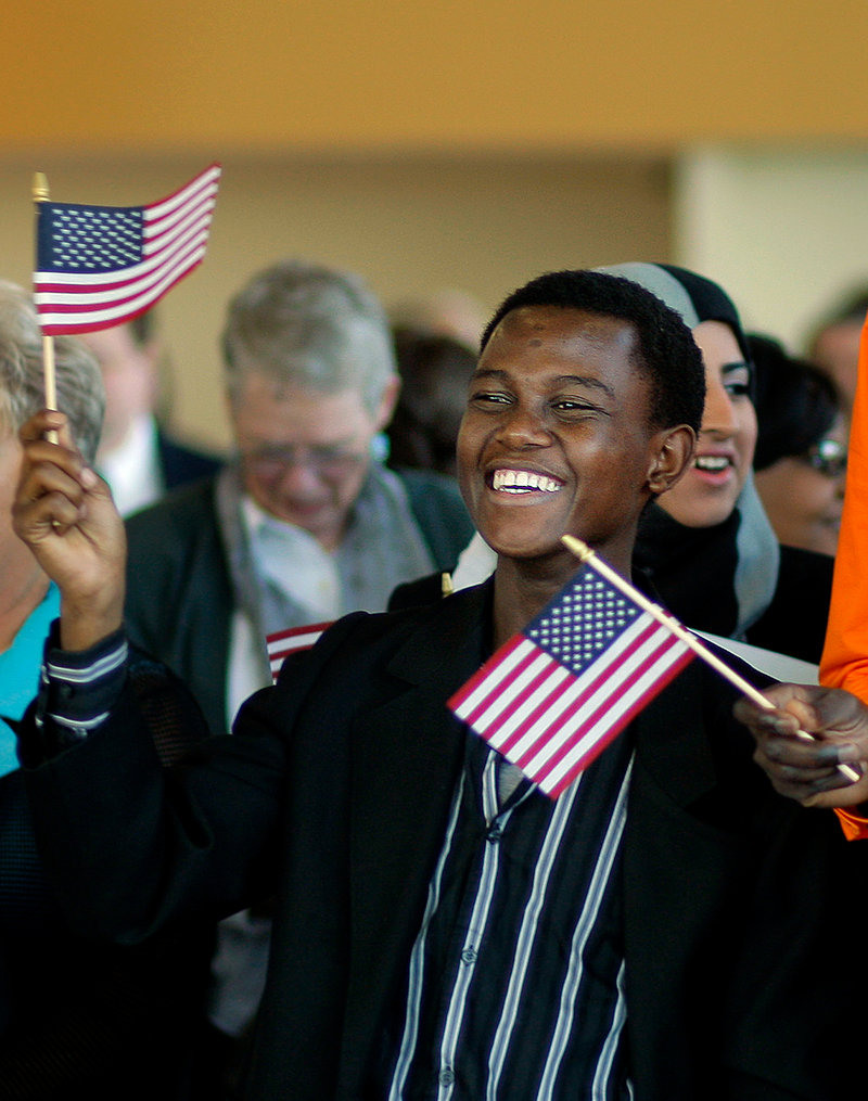 Mohamed Ali, 19, of Lewiston, originally of Kenya, waves his American flag in celebration after becoming a U.S. Citizen at a Naturalization Ceremony held at Ocean Gateway in Portland on Tuesday, September 17, 2013.