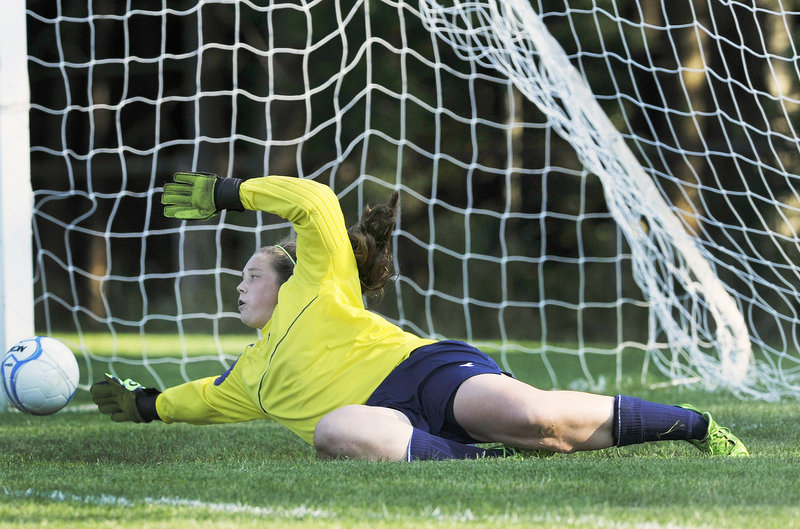 Jordyn Carr of McAuley makes a diving effort Tuesday but couldn’t quite stop a shot by Shaina Speight of Biddeford – the first goal in the Tigers’ 4-1 victory at Portland.