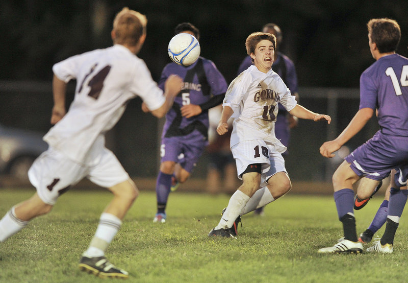Cody Elliott of Gorham, right, passes off to Erik Andreasen as the Rams attempt to press Deering during their SMAA schoolboy soccer game Tuesday night. Deering scored in the first minute and held on for a 1-0 victory.