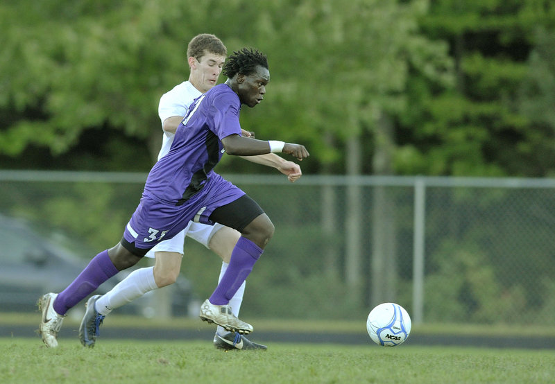 Stephen Ochan of Deering pushes the ball up the field while defended by Morgan Hager-Perry of Gorham. The teams are the top two in the Western Class A Heal point standings.