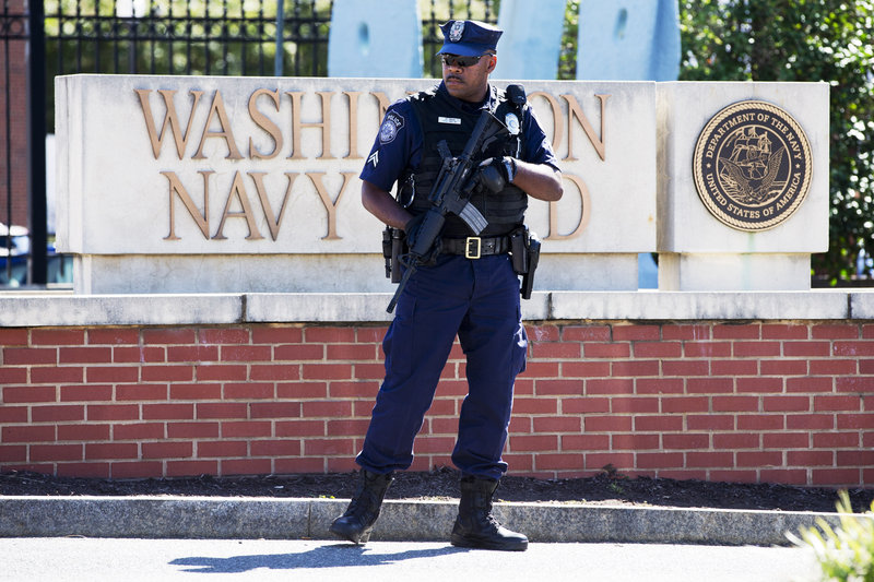 An armed officer who said he is with the Department of Defense, works near the gate at the Washington Navy Yard, closed to all but essential personnel, in Washington, on Tuesday, Sept. 17, 2013, the day after a gunman launched an attack inside the Washington Navy Yard on Monday, spraying gunfire on office workers in the cafeteria and in the hallways at the heavily secured military installation in the heart of the nation's capital. (AP Photo/Jacquelyn Martin)