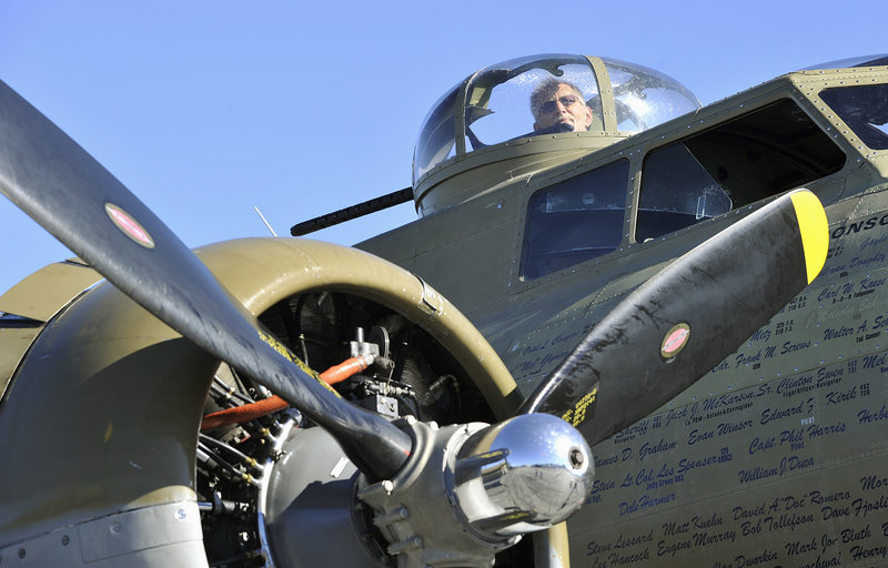 John Caylor, 73, of Dayton, an aficionado of vintage warplanes, looks out one of the gun turrets of a B-17 bomber, one of three World War II aircraft on display Wednesday at the Portland Jetport.