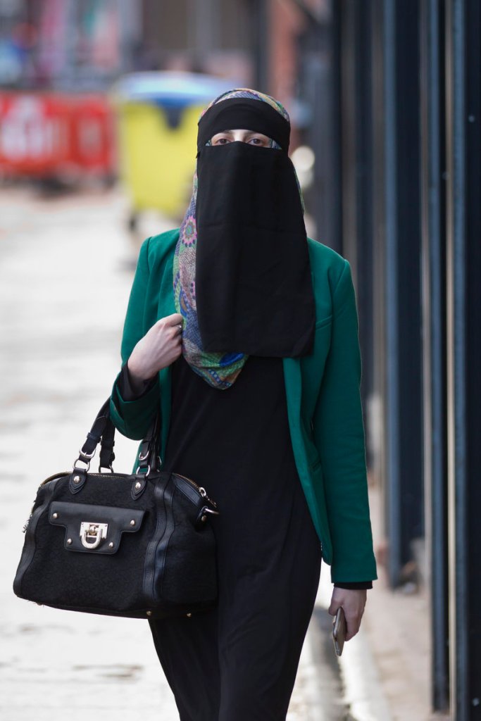 A woman walks Wednesday in Blackburn, England. A judge ruled that a Muslim woman may stand trial wearing a face-covering veil – but must remove it when giving evidence.