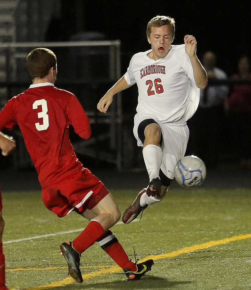 Scarborough’s Austin Doody goes airborne in an attempt to retain the ball as Sanford’s Evyn Nolette defends during the Red Storm’s 4-0 win Thursday.