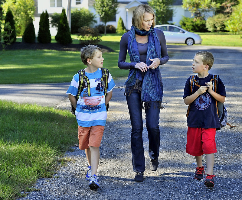 Moss walks from the school bus with her sons, Quinn and Rowen Hagerty. Having more time with them has been a benefit of leaving her TV station job.