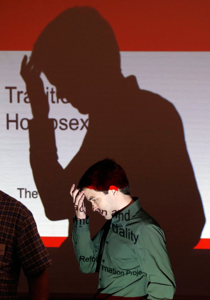 Matthew Vines walks past a projector at a conference in Prairie Village, Kan. Vines has gathered about 50 Christians to delve into his belief that the Scriptures do not condemn homosexuality.