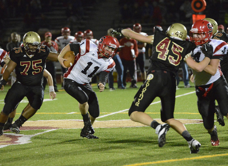 Scarborough quarterback Ben Greenburg tries to follow a block and avoid Thornton defenders Elijah Ayotte, left, and Jimmy Remmes during Friday night’s game at Hill Stadium in Saco.