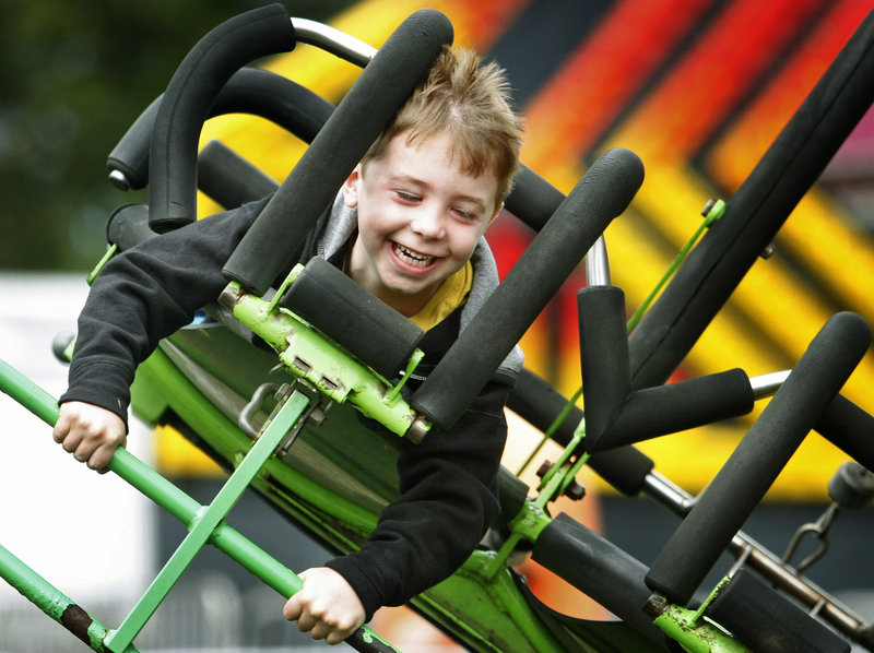 Ben Duda, 6, of Boston enjoys the wind and speed of flying on the Cliff Hanger ride on opening day at the Cumberland County Fair Sunday. Duda was visiting the fair with his grandfather, Fred Miller of Freeport.