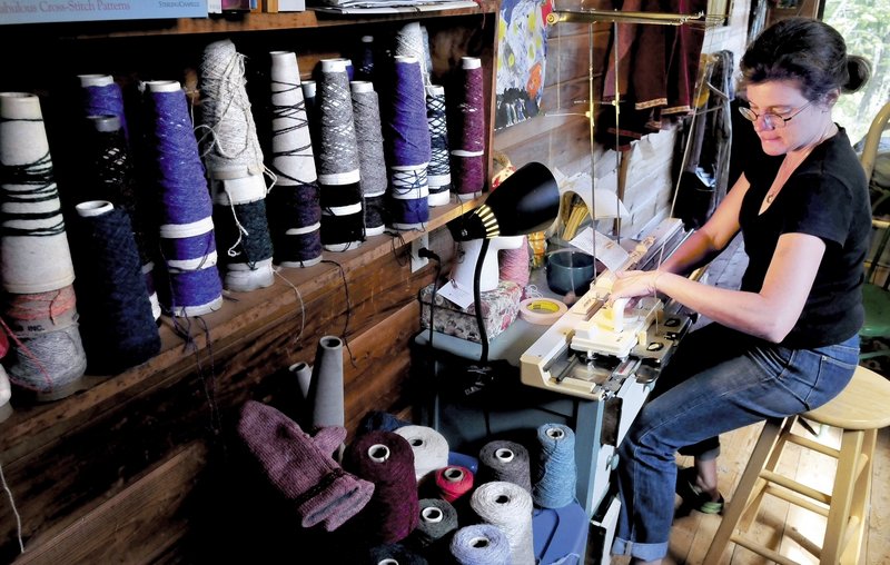 Karen Schorr operates her hand-powered knitting machine at her home in New Sharon. Schott will display her knitting machine and skills at the Lewiston/Auburn Mini Maker Faire on Saturday.