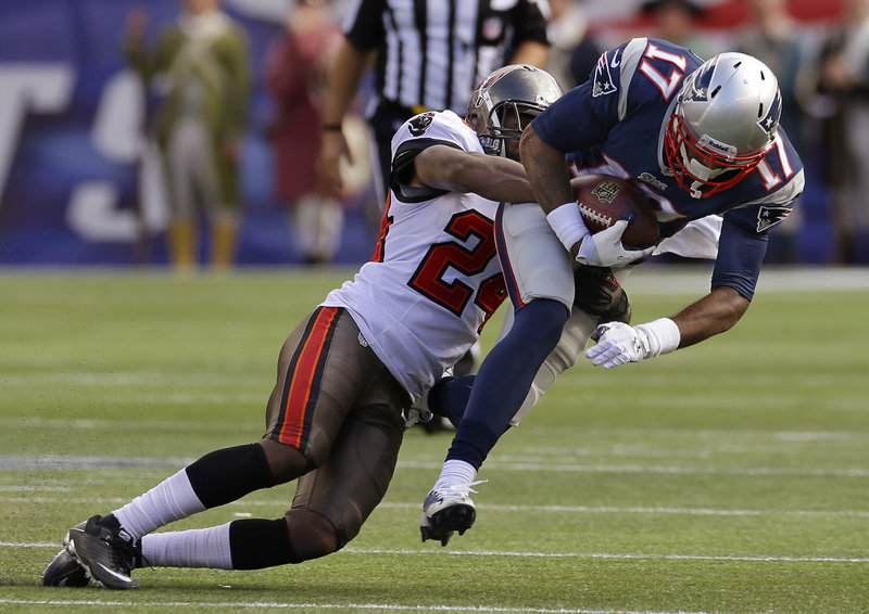 Patriots rookie Aaron Dobson is brought down by Tampa Bay’s Darrelle Revis after one of his seven receptions Sunday.
