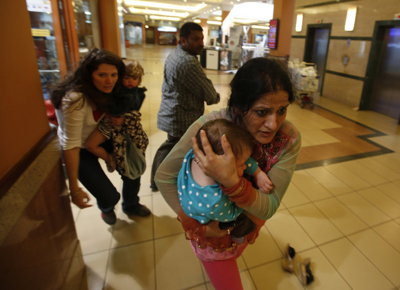 Women with children run for safety Saturday as police hunt the 10 to 15 armed militants who stormed the Westgate shopping centre in Nairobi. On Sunday, the military raided the mall to rout the gunmen.