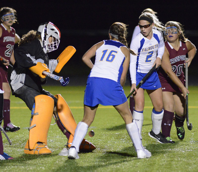 Freeport goalie Morgan Karnes makes a save as Mikey Richards, center, and Jillian Rothweiler look for the rebound during Falmouth’s 4-0 home victory Monday night in a Western Maine Conference field hockey game.