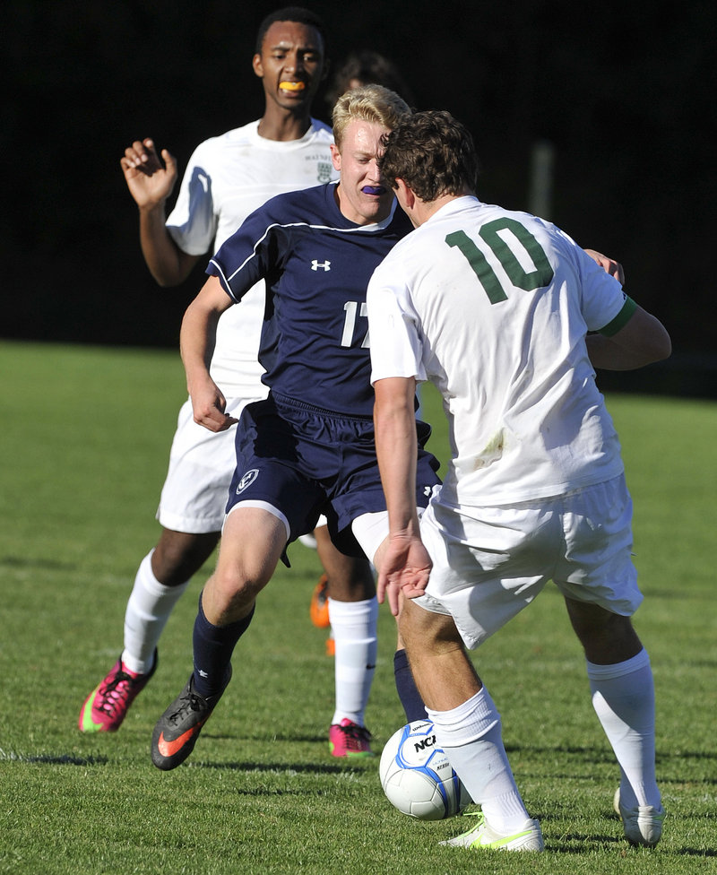 Travis Hamre of Yarmouth looks for room to dribble Tuesday while sandwiched between Henry Cleaves, foreground, and Elyse Bayizere of Waynflete during unbeaten Yarmouth’s 3-0 victory.