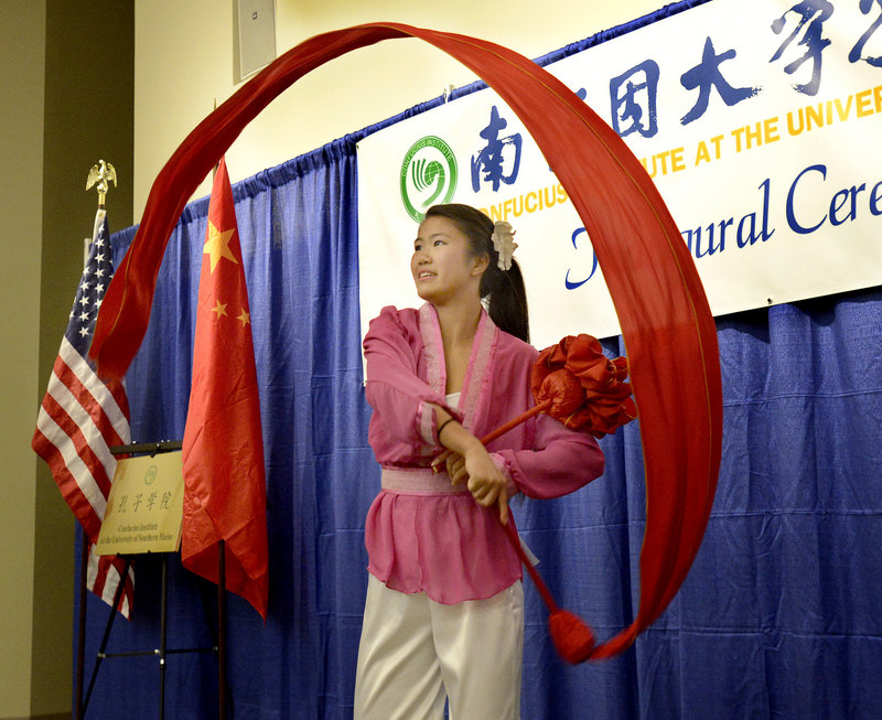 Nicole McCallum, with the Chinese and American Friendship Association of Maine, does a celebration dance during the inaugural ceremony for the Confucius Institute at the University of Southern Maine in Gorham on Sept. 25, 2013.