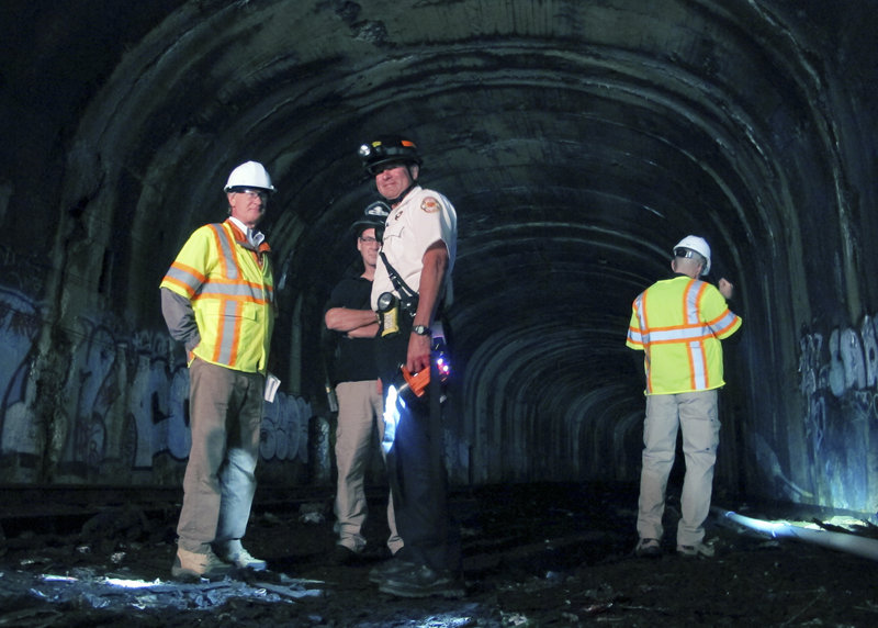 Rhode Island Gov. Lincoln Chafee, left, joins inspectors checking the condition of an abandoned railway tunnel Thursday, Sept. 26, 2013 in Providence, R.I. Chafee said he wanted to get a first-hand look at the condition of the mile-long tunnel, which was sealed off 20 years ago.