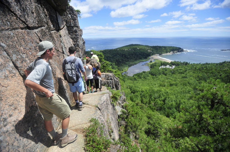 A line of hikers files up the Beehive Trail near Sand Beach at Acadia National Park in Bar Harbor. At the time this photograph was taken in July of 2014, The park was considering that it might have to close at the height of the fall foliage season if congress couldn't reach a deal on federal spending.
