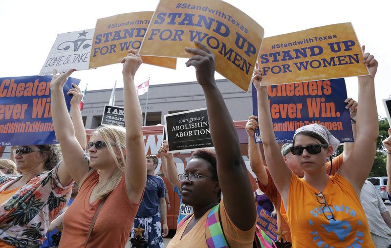 Opponents and supporters of a new, more strict abortion bill hold signs in Austin, Texas, earlier this summer. On Friday, a coalition of health-care providers in Texas filed a lawsuit to block the law as unconstitutional.