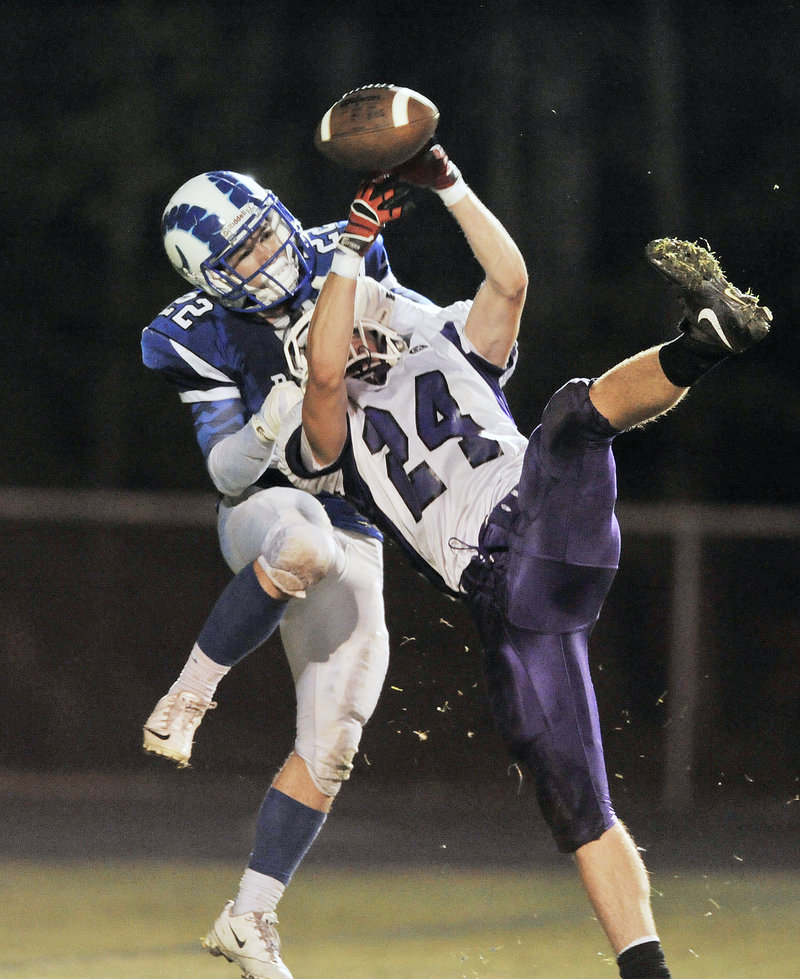 Noah Kreider of Marshwood, foreground, breaks up a pass intended for Larson Coppinger of Kennebunk in the second quarter Friday night. Kennebunk won 21-14 in a game between undefeated Western Class B opponents.