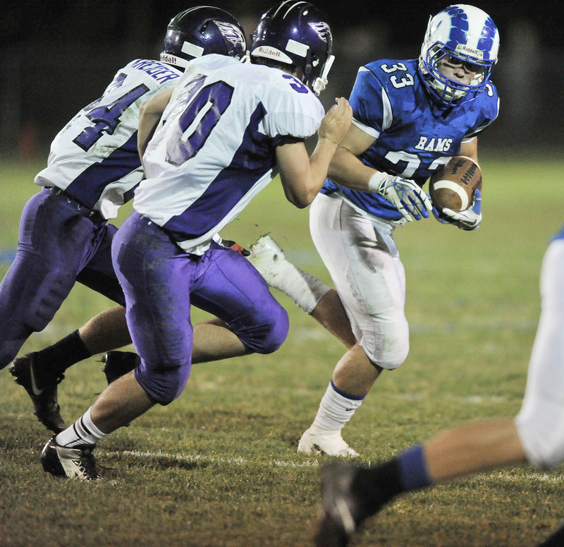 Nicco DeLorenzo of Kennebunk looks for a way to turn the corner against Noah Kreider, left, and Zach Doyon of Marshwood.
