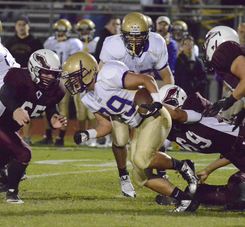 Cody O’Brien of Cheverus finds room to gain yards Friday night as Tyrell Gullatt of Windham attempts to make the tackle. Cheverus, ahead 28-14 at halftime, pulled away to a 57-22 victory at Windham.