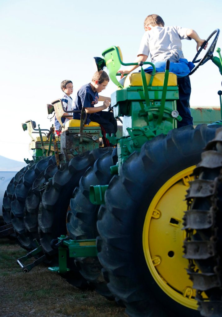 Children play on tractors displayed on opening day of the Fryeburg Fair on Sunday.