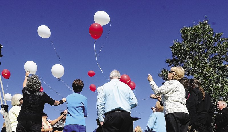 People watch a balloon release after the groundbreaking ceremony for the Parents of Murdered Children Maine chapter’s new monument Sunday in Augusta.