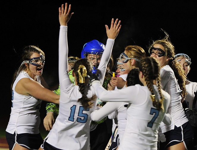 York players hug goalie Olivia Golini as they celebrate their 6-0 win over Spruce Mountain in the Western Class B field hockey championship game Tuesday at Thornton Academy.