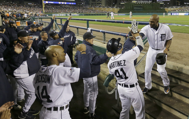 Torii Hunter of the Detroit Tigers is greeted by Victor Martinez after scoring on a single by Miguel Cabrera in the second inning of Game 4.