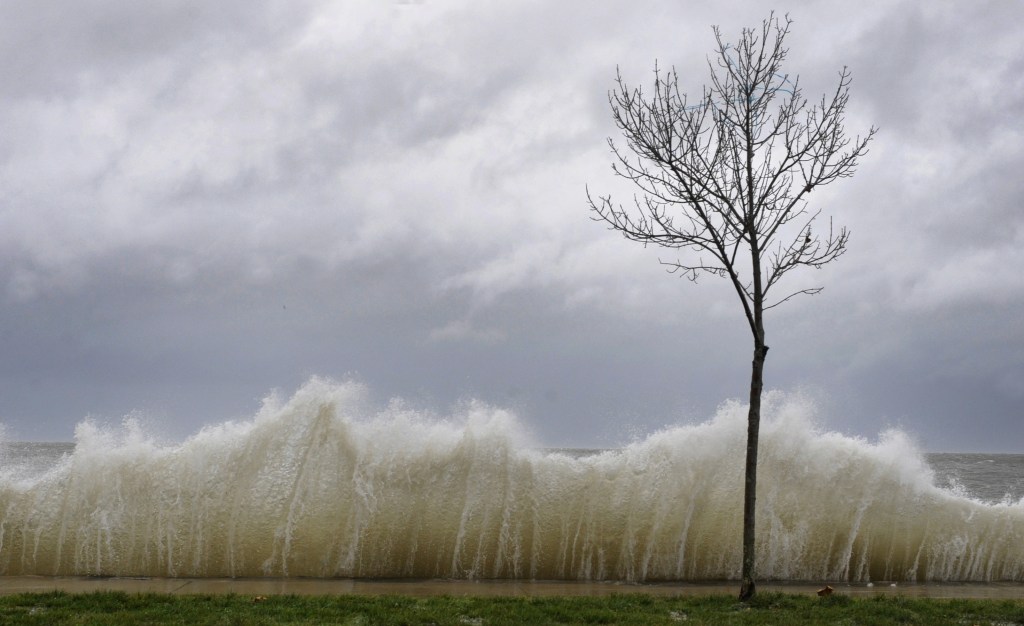 A storm surge hits a barrier next to a small tree as winds from Superstorm Sandy reach Seaside Park in Bridgeport, Conn., in this Oct. 29, 2012, file photo. Sandy set historical maximum recorded water levels at Bridgeport and elsewhere on the coast.