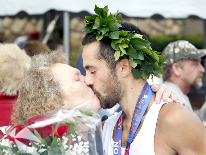 Rob Gomez of Saco receives a congratulations kiss from his mother, Connie, in Portland on Sunday, after winning the Maine Marathon on Sunday.
