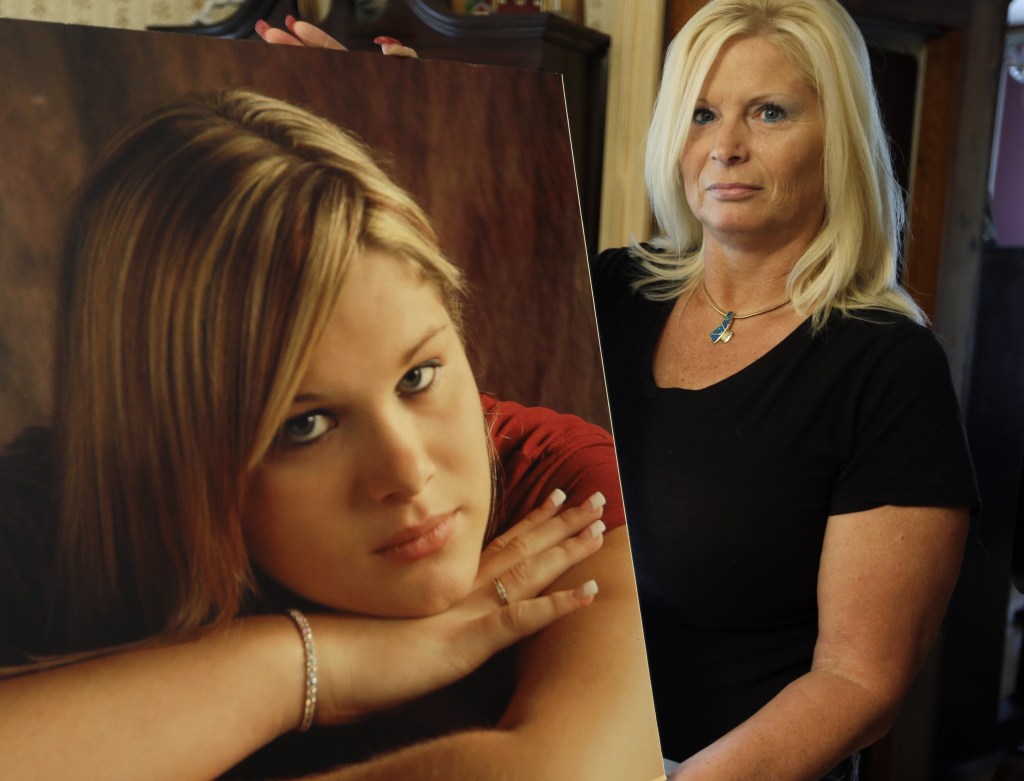 Lisa Moore displays a photo of her daughter, Alexis, in her home in Terre Haute, Ind. The Moores had continued to pay their daughter’s cellphone bill to preserve her greeting.