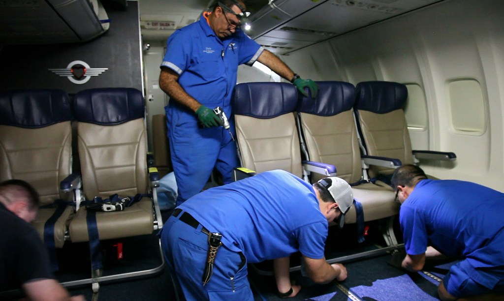 Southwest Airlines aircraft technicians install skinnier seats on a 737 at the carrier’s headquarters in Dallas. Southwest says passengers will have the same amount of legroom even though the new seats allow for another row aboard each plane.