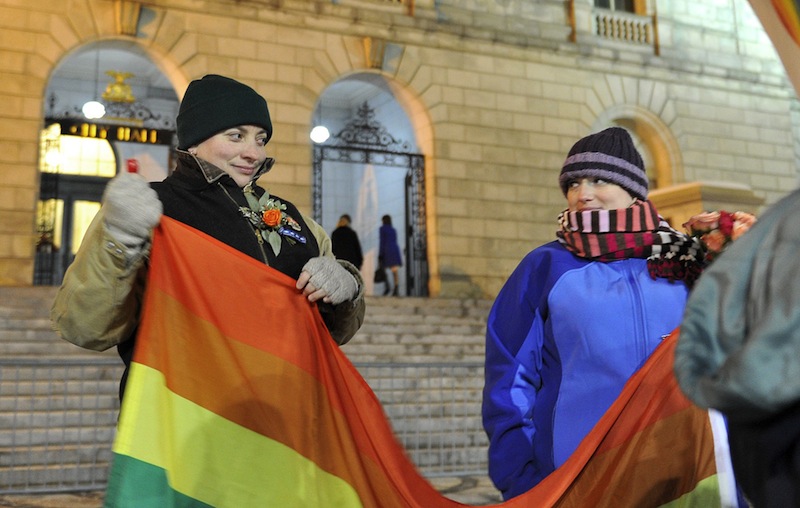Amber Hardy of Portland and Amanda Poulin glance at each other as they unfurl a gay pride flag in front of Portland City Hall Friday, December 28, 2012 before the first same sex marriages were performed in Maine. Portland ranks among the U.S. cities with the highest concentration of households headed by same-sex couples, a new analysis of census data shows.