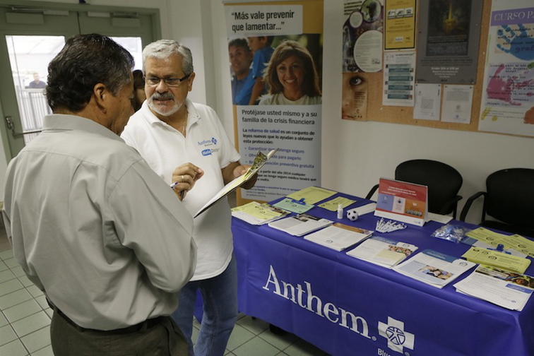 Alberto Pizon, right, a representative of Anthem BlueCross BlueShield Latino Health Access group provides free information to Paulino Zarate, 65, left, on the new health options available during a health fair promoted at the Binational Health Week event held at the Mexican Consulate in Los Angeles Tuesday, Oct. 1, 2013. Thousands of Californians seeking to buy their own health insurance flooded call centers with questions and overloaded the state’s online marketplace Tuesday on the first day of a new federal health care law that will dramatically change the way Americans buy health insurance.