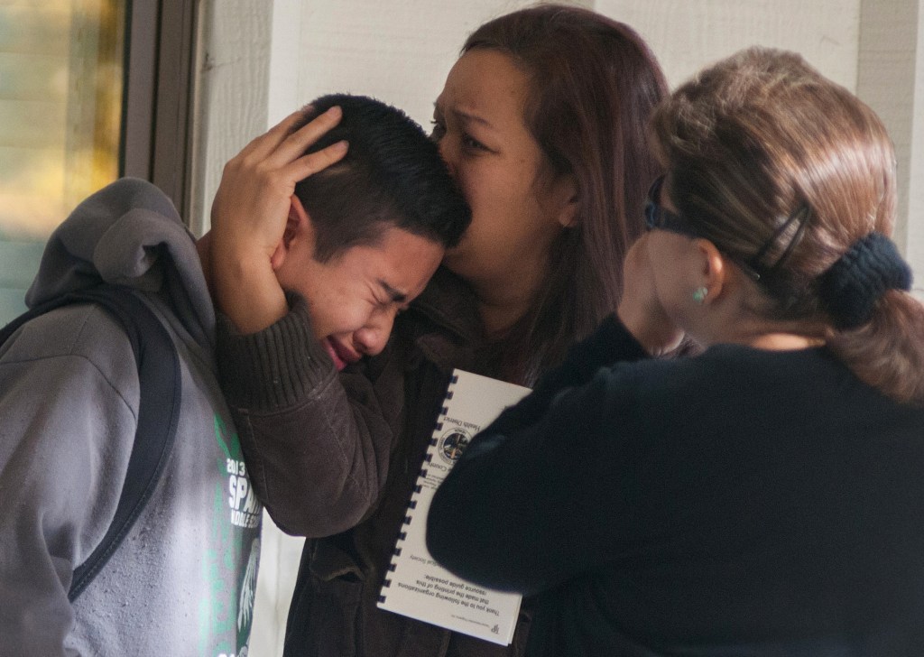 A Sparks Middle School student cries and is comforted after being released from Agnes Risley Elementary School, where some students were evacuated to after a shooting at Sparks Middle School in Sparks, Nev., on Monday.