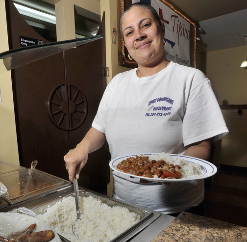 Server Mayda Perez serves up a plate of rice and beans at Tipico Dominicano Restaurant in Portland.