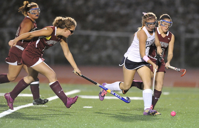 Haley Boydon of Yarmouth pushes the ball through the Freeport defense, attempting to rush past Abby Smith, right, during their Western Maine Conference field hockey game Tuesday night. Yarmouth scored twice in the second half at home for a 2-0 victory.