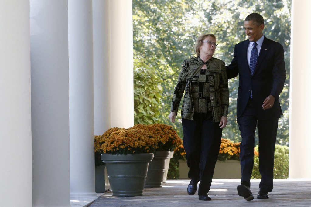 In this Oct. 21 file photo, President Barack Obama walks from the Oval Office to the Rose Garden of the White House in Washington with Janice Baker, who runs a small business in Selbyville, Del., and was the first woman to enroll in the Delaware health care exchange, for an event on the initial rollout of the health care overhaul. The Obama administration says it’s granting a six-week extension until March 31 for Americans to sign up for coverage next year and avoid new tax penalties under the president’s health care overhaul law.