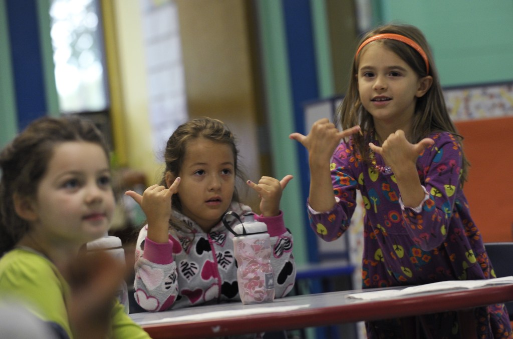 Channing Morgan, from left, Brooklyn Olds, and Grace Whittaker learn sign language during a lesson at a homeschooling co-operative at Andrews Air Force Base, Md.