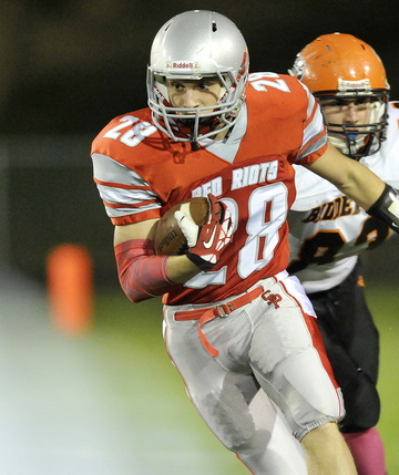 South Portland running back Joey DiBiase gets some running room after getting outside of Biddeford’s Dan Copeland during Friday night’s win in South Portland. The Red Riots improved to 5-2 on the season.