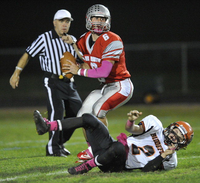 South Portland quarterback Duncan Preston shakes off the tackle of Biddeford’s Corey Creeger and looks for an opening downfield during Friday's 55-24 win.