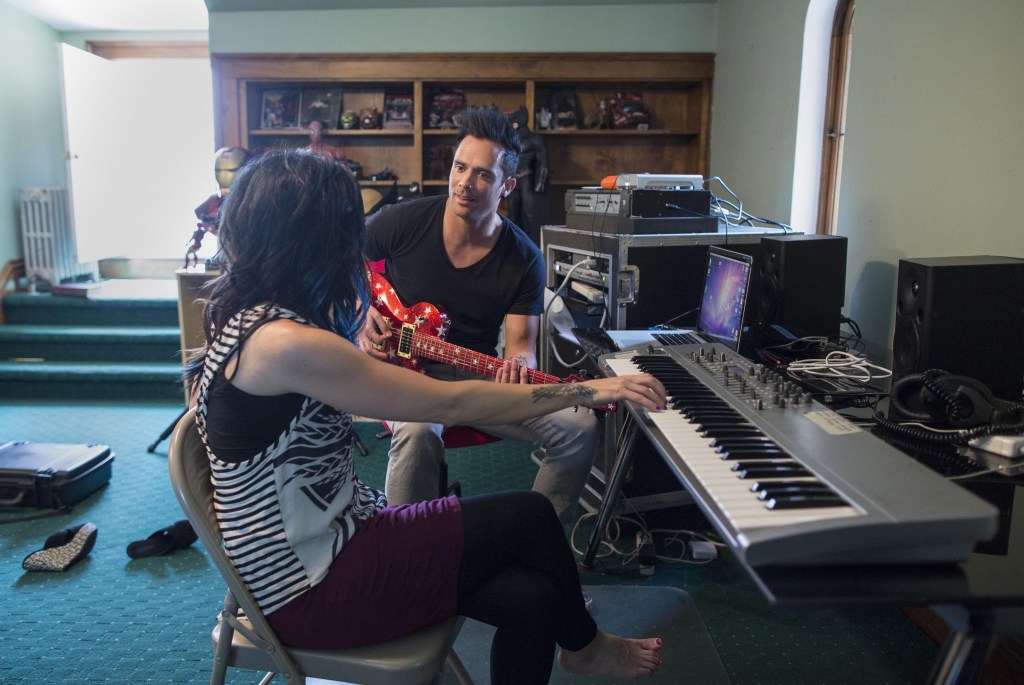 In this July 22, 2013 photograph, married musicians Korey Cooper, left, and John Cooper of the Christian rock band Skillet play music inside of their home in Kenosha, Wis. Skillet released its eighth album “Rise,” this June _ coming off its best-selling album “Awake,” which went platinum after three years. (AP Photo/Scott Eisen)