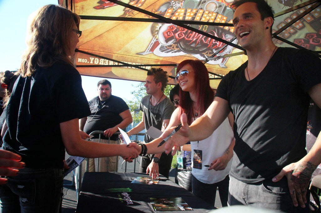 Members of the Christian rock band Skillet, from right, John Cooper, Jen Ledger, Korey Cooper and Seth Morrison, sign autographs for the fans they affectionately call panheads before a show in Chicago.