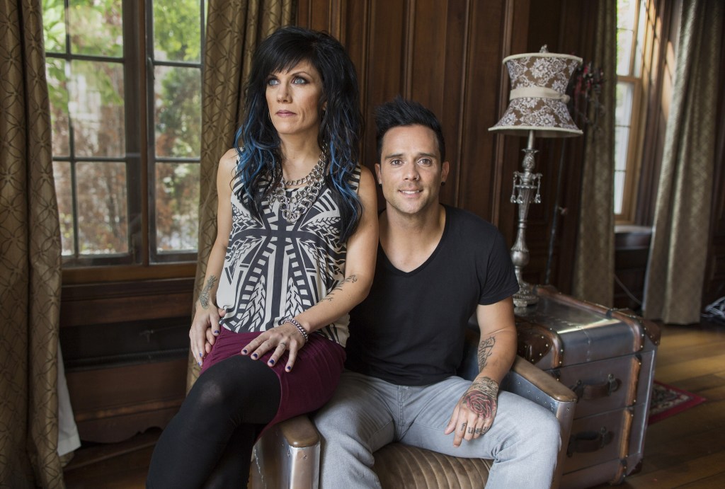 In this July 22, 2013 photograph, married musicians Korey Cooper, left, and John Cooper of the Christian rock band Skillet pose for a portrait inside of their home in Kenosha, Wis. Skillet released its eighth album “Rise,” this June _ coming off its best-selling album “Awake,” which went platinum after three years. (AP Photo/Scott Eisen)