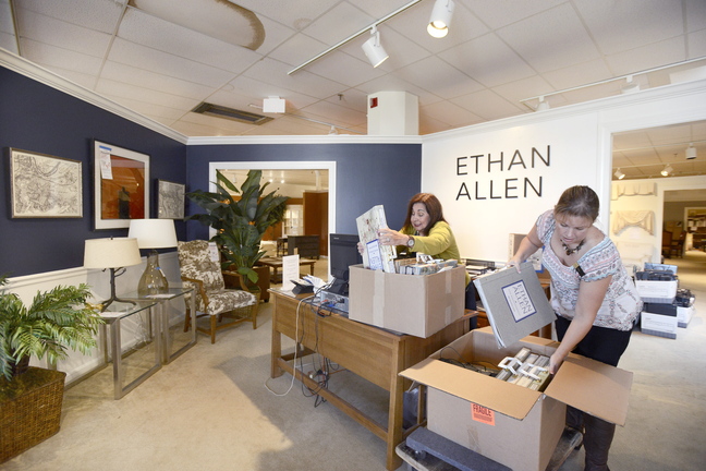 Employees Lenora Bourgeois and Julie Parent pack wallpaper books at the Ethan Allen furniture store in South Portland in preparation for their move into a new store in Portland.