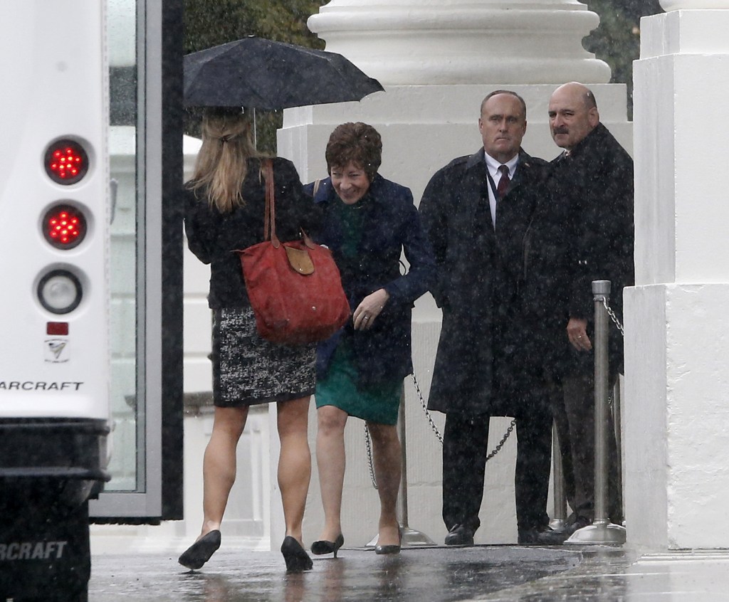 Sen. Susan Collins, R-Maine, walks in the rain back to her bus at the North Portico of the White House in Washington on Friday after she and Republican senators met with President Barack Obama regarding the government shutdown and debt ceiling.